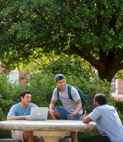 Students outside around a table