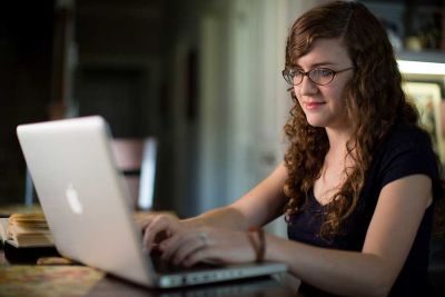 student in her dorm programming on her laptop