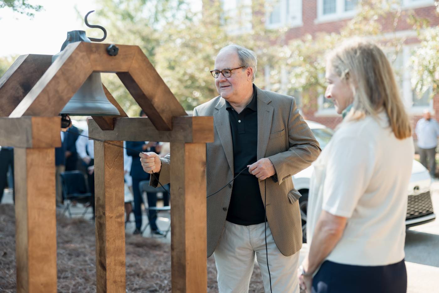 John Cox, great-grandson of Mark Perrin Lowrey Berry, the last president of Hillman College, rings the Hillman Bell to summon attendees to Mississippi College's 200th academic session while his sister, Carol Heidelberg, observes.