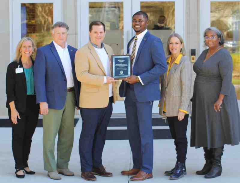 Dr. Steven J. Jones, third from right, receives the 2021 Higher Education Alumnus of the Year Award from Dr. Blake Thompson, third from left, Mississippi College president, and other MC leaders, from left, Dr. Cindy Melton, Dr. Jim Turcotte, Dr. Debbie Norris, and Dr. Stephanie Carmicle.