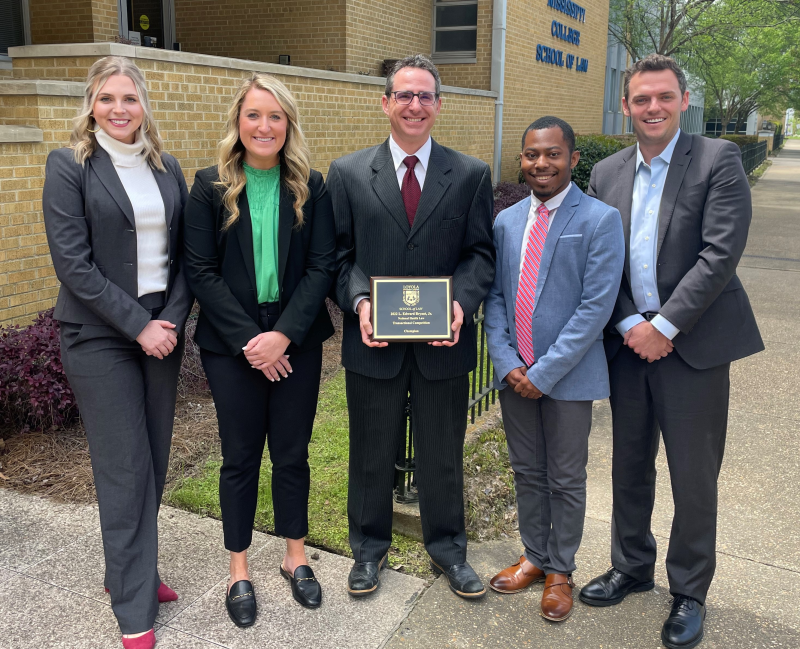 Jonathan F. Will, center, an associate dean at the Mississippi College School of Law, holds the 2022 L. Edward Bryant Jr. National Health Law Transactional Competition championship plaque won by the MC Law team comprised of, from left, McKenna Cloud. 3L; Megan Donaldson, 2L; RJ Lewis, 2L; and James Tulp, 2L.