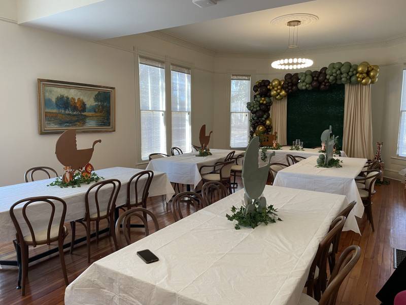 Removing the double-sided fireplace that once separated the parlor from the dining room in the Latimer House provides one large area that can accommodate dozens of guests, as this room arrangement for a baby shower indicates.
