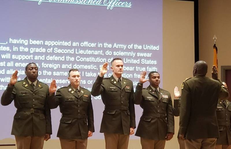 James Brooks, second from left, and Caleb Hall, third from left, recite the Oath of Commissioned Officers during the commissioning ceremony April 29.