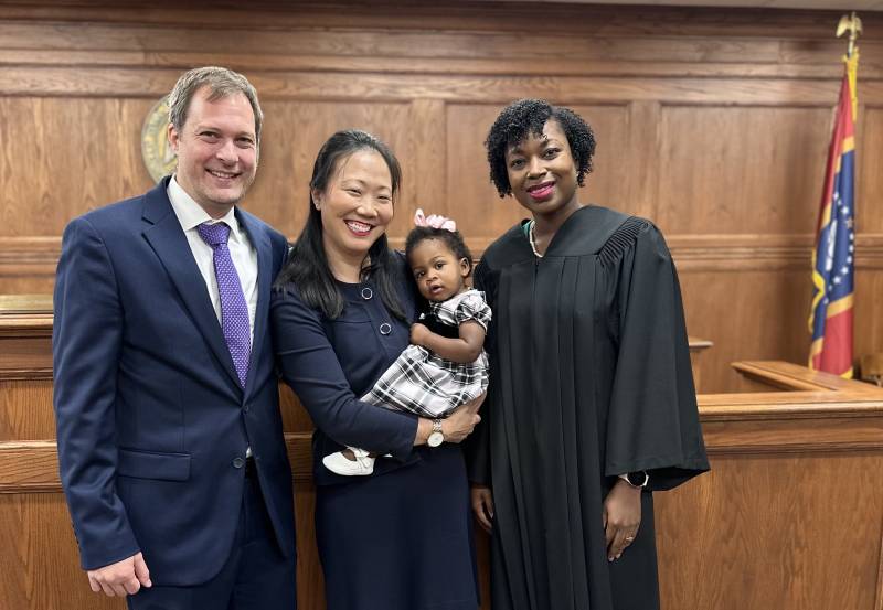 Minutes after successfully completing Lainey's adoption, parents Matthias Krenn and Emily Stanfield savor the moment with their new daughter and Judge Tametrice Hodges, right.