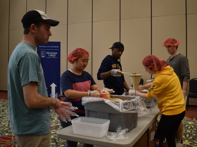 MC volunteers package dry goods to help feed impoverished people around the globe.