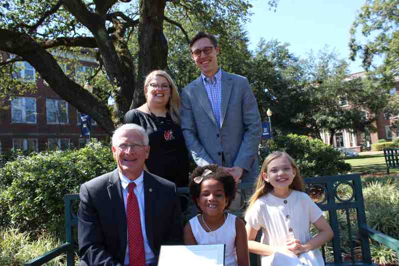 U.S. Sen. Roger Wicker of Mississippi presents the Angels in Adoption award to the Wallace family. Standing in the back row: Hannah Wallace and her husband John. Sen. Wicker sits by ZZ Wallace and her sister, Ivy Wallace on the Mississippi College campus.  photo by Andy Kanengiser MC University News Coordinator