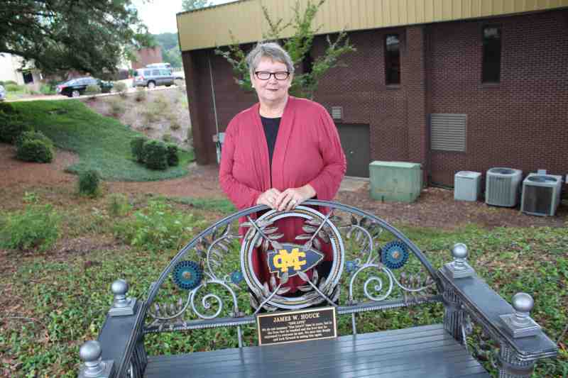 Linda Houck Willard of Georgia stand by the bench at Mississippi College that honors the memory of her son, James Houck.