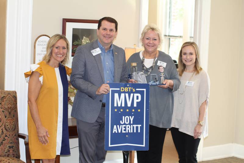 Cindy Melton, left, dean of the School of Education, and Kayla Acklin, right, chair of the Department of Counseling, observe as MC President Blake Thompson presents the DBT's MVP Award for September to Joy Gore Averitt, administrative assistant in the Department of Counseling.