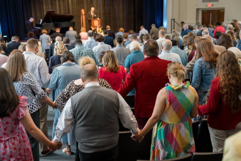 The Mississippi College family holds hands during a prayer to close the 2025 tvConvocation in Nelson Hall. 