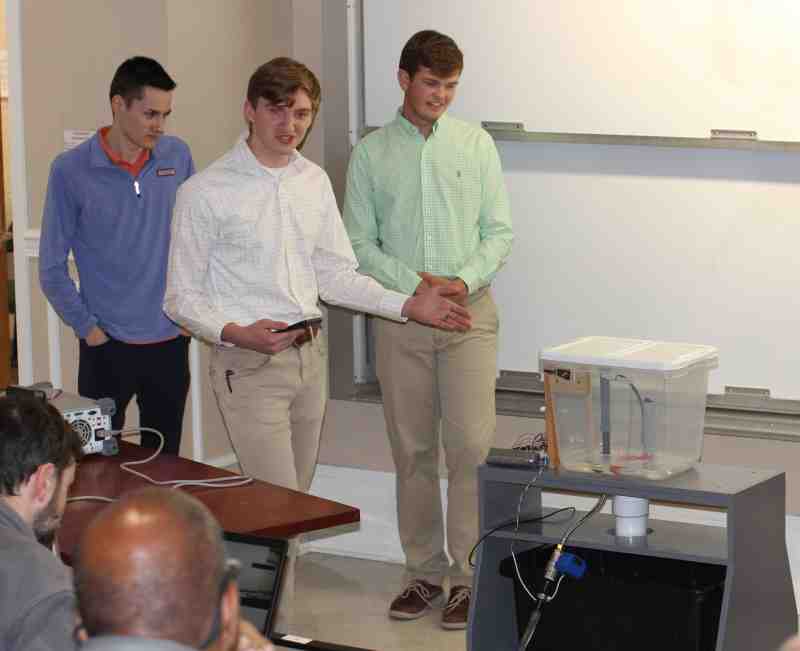 Zack Myers and his team demonstrate the capabilities of the lavatory water sensor prototype during a public exhibition of the electrical engineering students' senior projects.