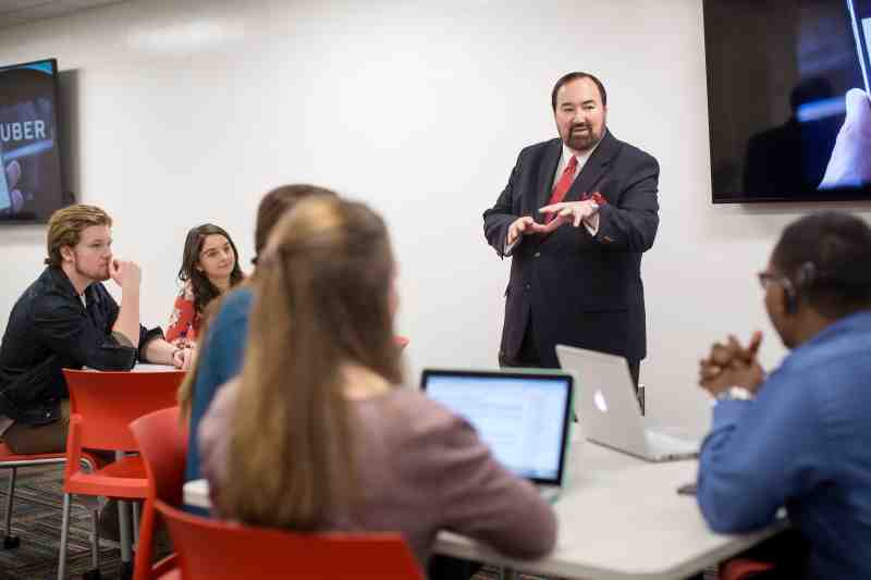 Professor John Brandon instructs MC business students in a Self Hall classroom.