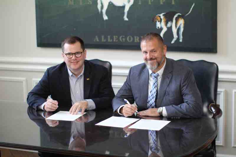 Dr. Blake Thompson, left, MC president, and Dr. David L. Herndon, Saint Augustine School headmaster, sign the dual enrollment agreement June 30.